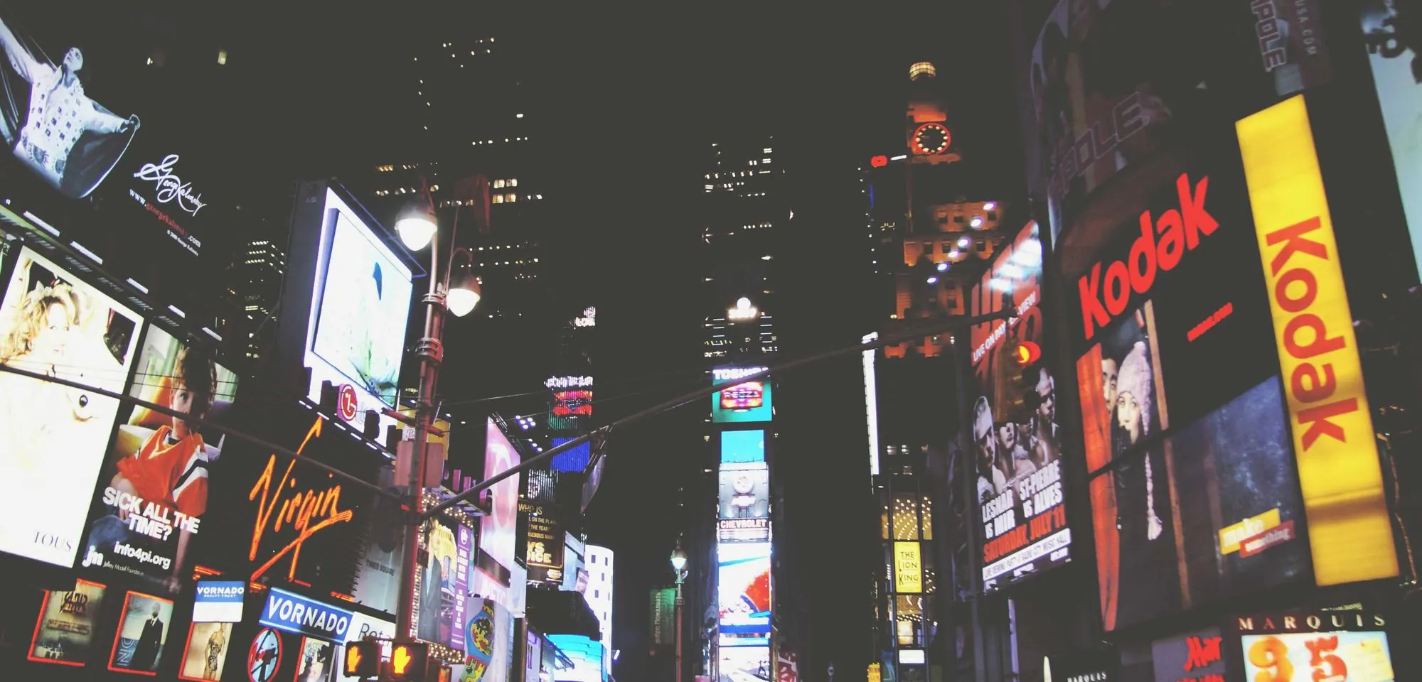 Neon billboards lighting up a city street at night