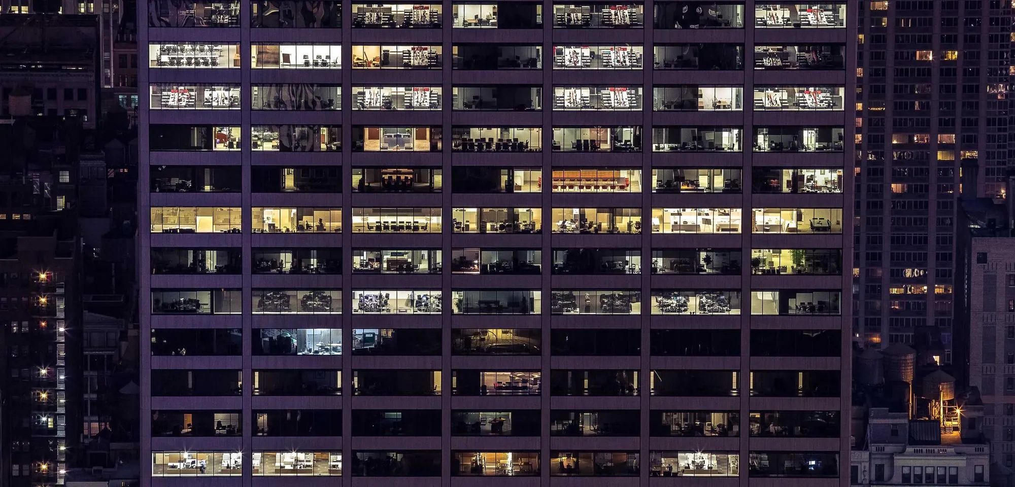Lit windows across a tall building at night